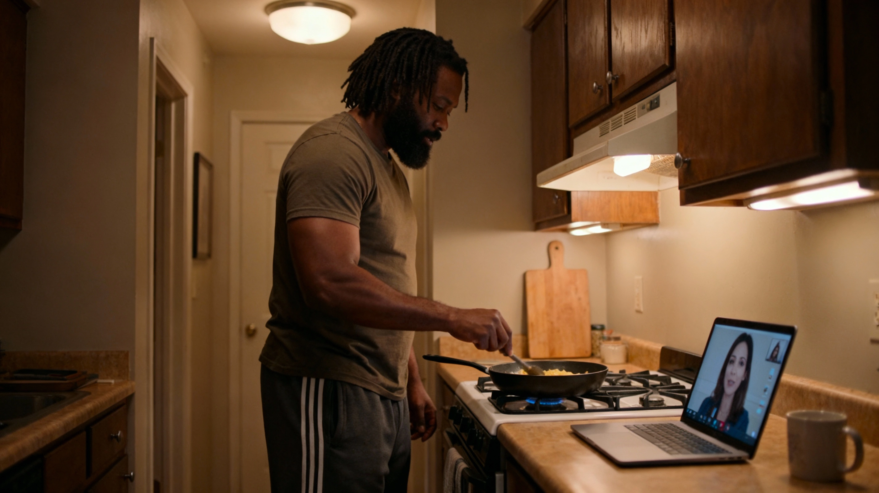 Black man cooking something simple during a low effort video date in his kitchen